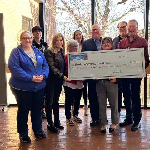 Village of Skokie Downtown Merchants present a donation check to Skokie Community Foundation with funds raised from the Downtown Skokie Cookie Walk.